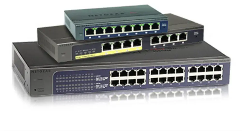 Stack of three NETGEAR Ethernet switches in varying sizes, with the smallest on top featuring 5 ports, the middle one with 8 ports, and the largest at the bottom with 24 ports, all displayed against a white background with reflective surface.